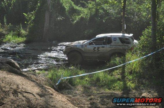 1999 Isuzu Vehicross navigating a muddy off-road course, with 'Darlington Off-Road' text visible on the door
