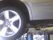 2003 Ford Crown Victoria - A silver sedan is raised on a mechanic's lift, showing its wheel and undercarriage.
