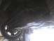 2003 Ford Crown Victoria - The underside of a vehicle is viewed from below while it is elevated on a lift.