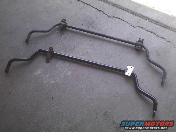 Two black sway bars on a concrete surface. One is above the other