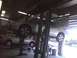 2003 Ford Crown Victoria - A silver 2003 Ford Crown Victoria is raised on a car lift in a service bay.