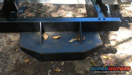 Black metal vehicle frame section with debris on it