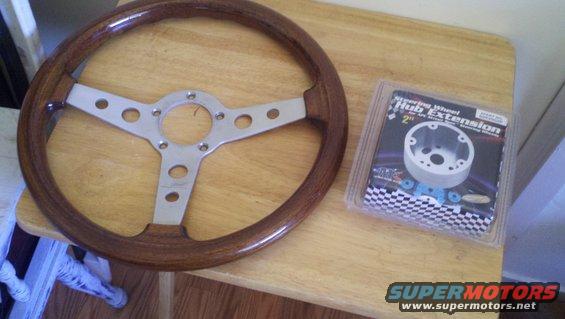 Wooden steering wheel with polished metal spokes and a packaged steering wheel hub extension kit