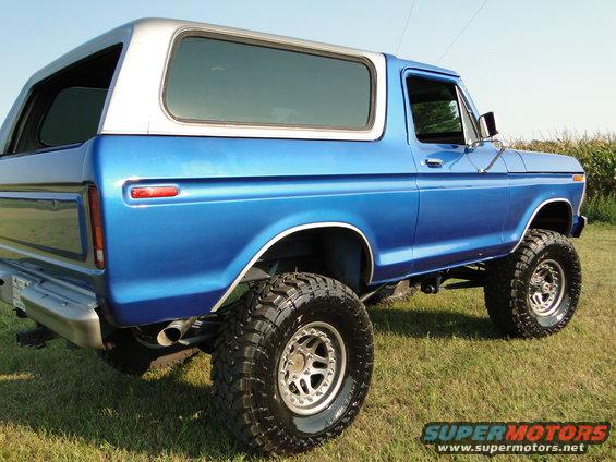 Blue lifted 1978 Ford Bronco with silver top parked on grass