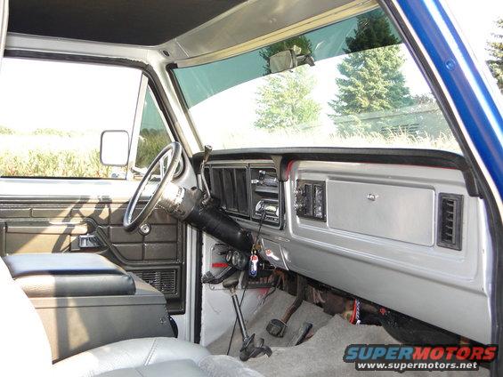 1978 Ford Bronco interior, dashboard with radio and vents, grey seats, column shifter, driver's side view