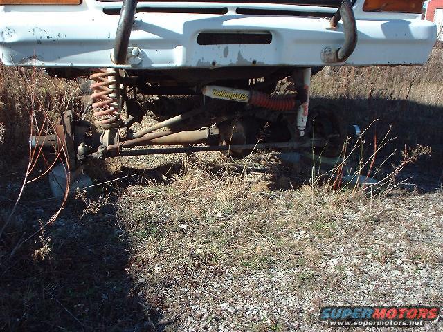 Front suspension and bumper of a white vehicle with "Hellmaster" shocks visible