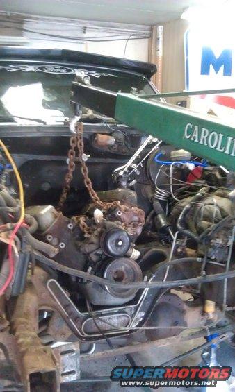 1993 Ford Bronco engine bay with engine hoist lifting the engine. Dark green exterior