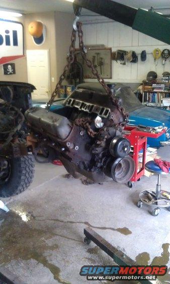 Engine suspended by chains, being removed from a vehicle