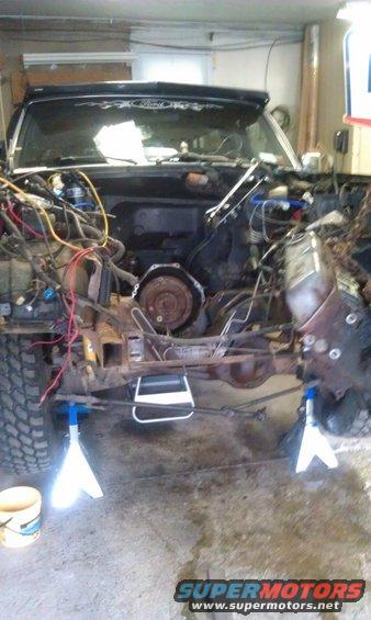 1993 Ford Bronco front end disassembled on jack stands, engine bay exposed