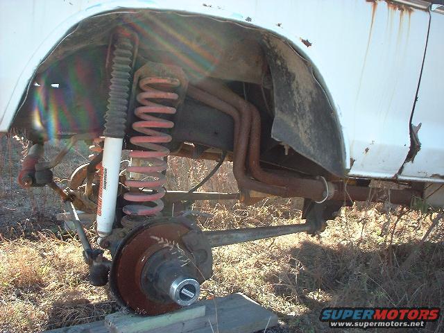 Close-up of a rusty Ford Bronco front suspension with coil spring and shock absorber