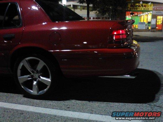red sedan rear quarter panel with aftermarket wheels