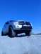 2004 Dodge Durango - A silver SUV with a bull bar and off-road tires is captured from a low angle against a clear blue sky.