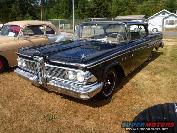 Black 1958 Edsel sedan with chrome grille and trim, parked on dry grass