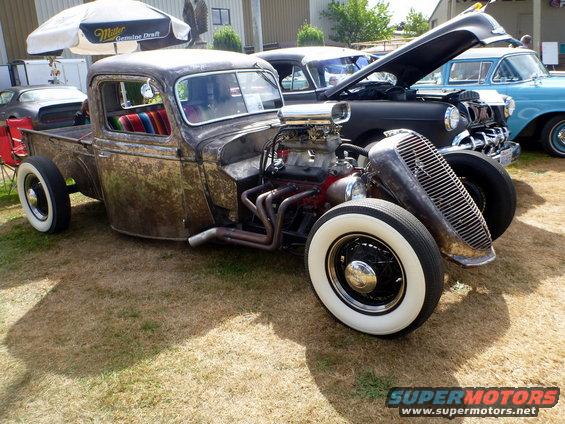 Rat rod pickup truck, exposed engine, wide whitewall tires, colorful interior