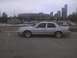 2003 Ford Crown Victoria - A silver 2003 Ford Crown Victoria is parked in a lot with a marina and city skyline in the background.