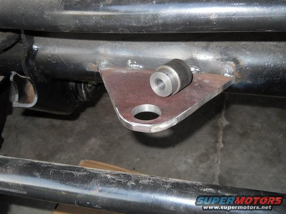 Custom metal bracket welded to frame, holding a rubber isolator with a metal sleeve