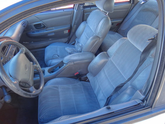 Interior of a 1993 Ford Taurus showing front seats, steering wheel, and dashboard