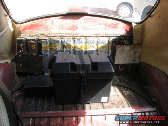 Red vehicle interior trunk with a black battery box and a black electronics box