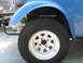 1970 Volkswagen Beetle - Close-up of a modified Volkswagen Beetle, likely a Baja Bug, showing its front wheel and suspension.