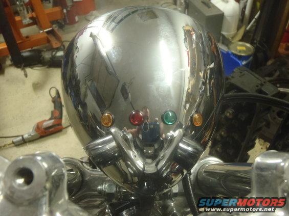 Chrome motorcycle headlight with amber, red, and green indicator lights