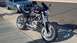 1996 Buell S1 Lightning w/Fairing - Motorcycle parked on sidewalk with a blue Ford Mustang behind it.