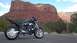 1996 Buell S1 Lightning w/Fairing - A black motorcycle is parked on the side of the road with a scenic red rock landscape behind it.