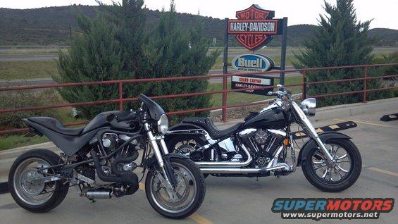 Two motorcycles parked in front of a Harley-Davidson and Buell dealership sign