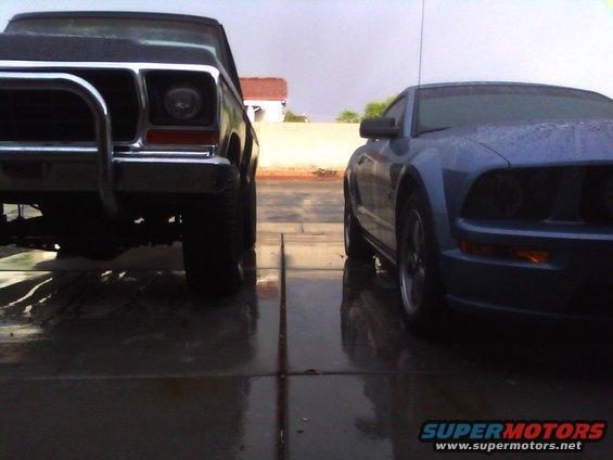 Blue Ford Mustang parked next to a dark-colored truck