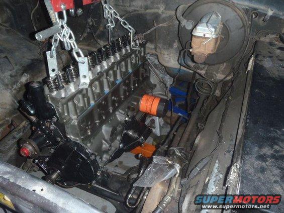 Engine being lowered into engine bay with chains and engine hoist