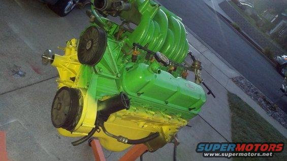 Green and yellow painted engine on an orange stand