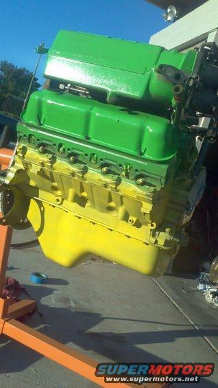 Engine painted green and yellow, mounted on an orange engine stand