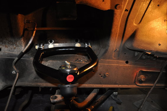 Black upper control arm with red RH sticker, part of a vehicle's front suspension