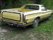1974 Ford Ranchero - This 1974 Ford Ranchero pickup truck is seen from the rear, parked outdoors with overgrown vegetation.