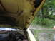 1974 Ford Ranchero - The underside of the hood shows significant rust damage, with the engine bay visible below.