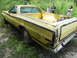 1974 Ford Ranchero - A yellow 1974 Ford Ranchero sits in overgrown grass, viewed from the rear three-quarter perspective.