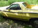 1974 Ford Ranchero - A yellow Ford Ranchero with black trim is parked outdoors in tall grass.