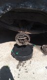 Close-up of a disassembled drum brake assembly sitting in a black pan on concrete