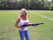 1992 Ford Bronco - A woman stands in a field holding a shotgun, with trees in the background.