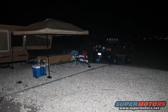 Red SUV with off-road lights parked at a campsite