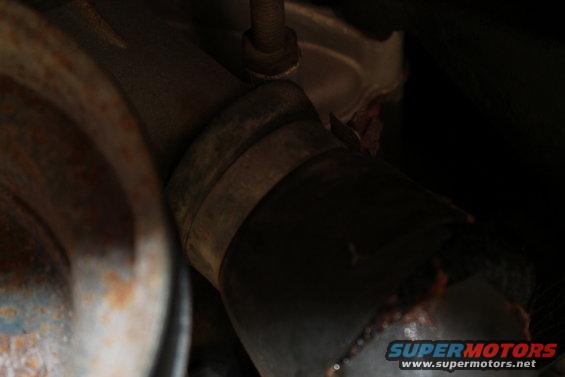 Close-up of a rusty exhaust pipe clamp and section of pipe