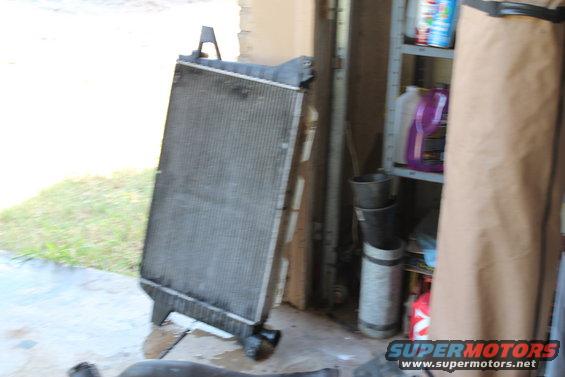 Radiator leaning against a wall, with shelves and bottles in the background