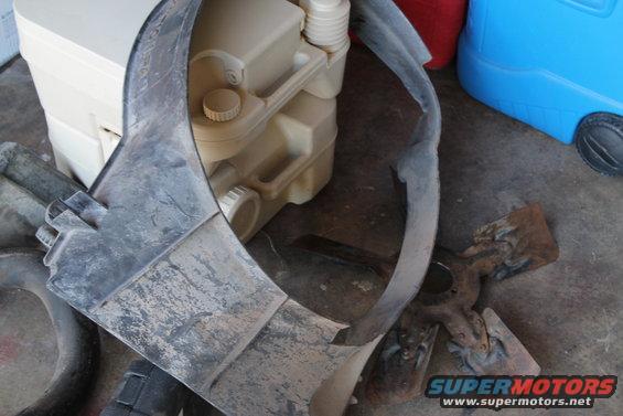 Plastic shroud and a beige water jug on the ground