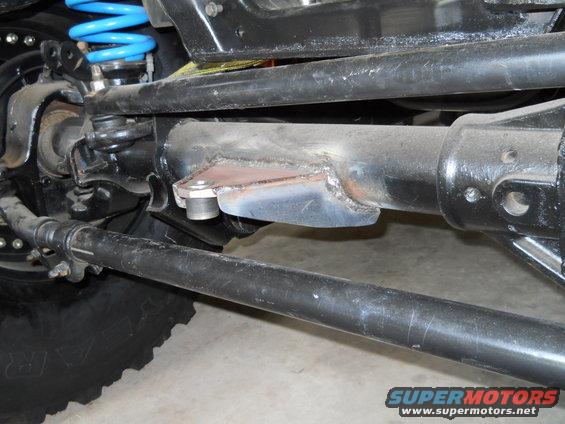 Close-up of vehicle's front axle and suspension with blue coil spring
