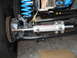 1992 Ford Bronco - This image shows a close-up of a vehicle's steering and suspension components, focusing on a power steering assist cylinder.