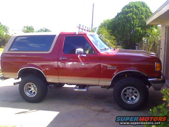 Red 1990 Ford Bronco side view with tan top