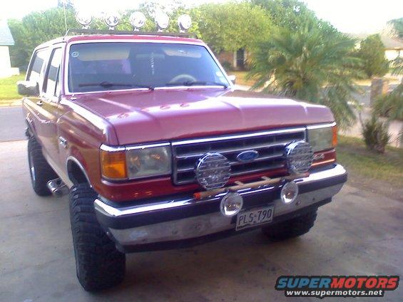 Red 1990 Ford Bronco front view with roof lights and fog lamps