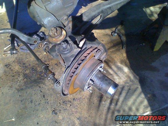 Vehicle suspension part with brake rotor and hub assembly on concrete floor