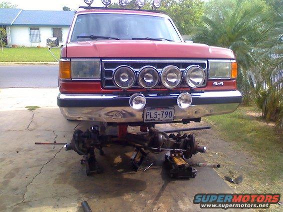 1990 Ford Bronco front view, red, with front axle removed and supported by jacks