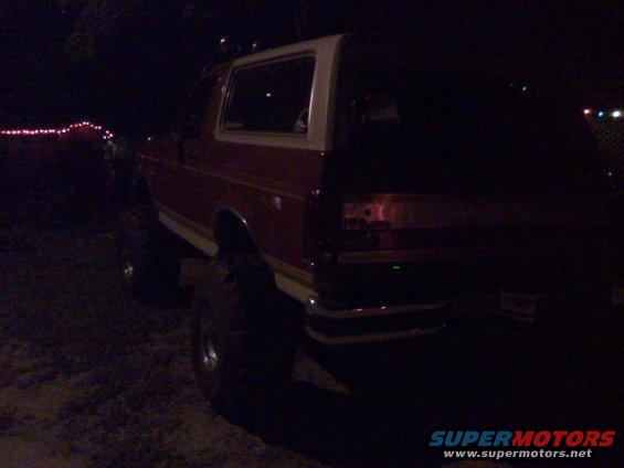 1990 Ford Bronco rear view at night, red with white top