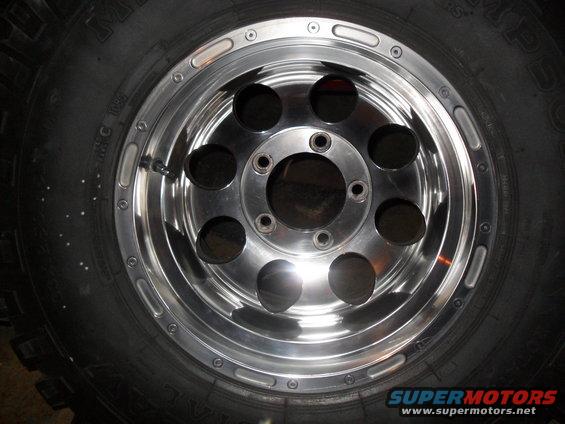 Chrome wheel with six circular cutouts and a black tire